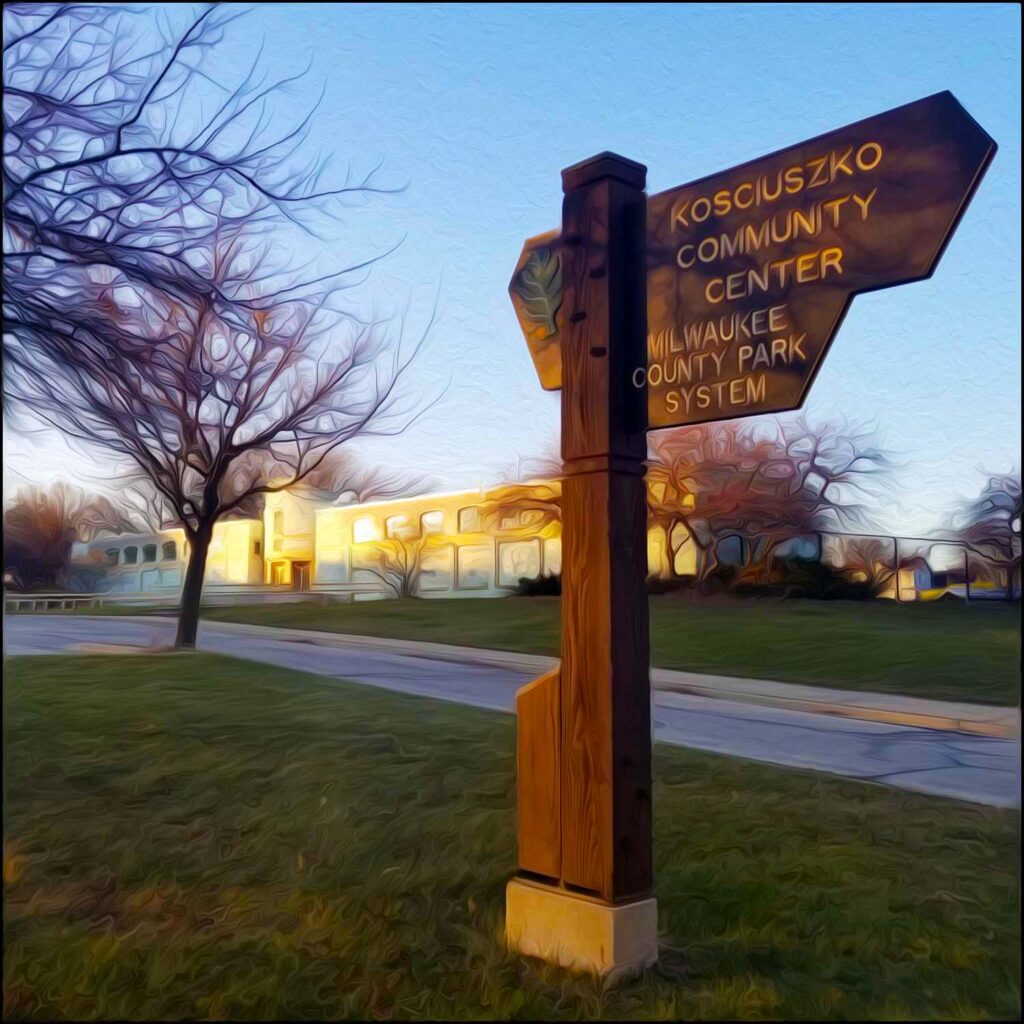 Picture of Kozy sign and pool house. Parks part of Milwaukee's Emerald Necklace's Oak Leaf Trail are marked with a green oak leaf and acorn near the top left corner of their brown park signs.